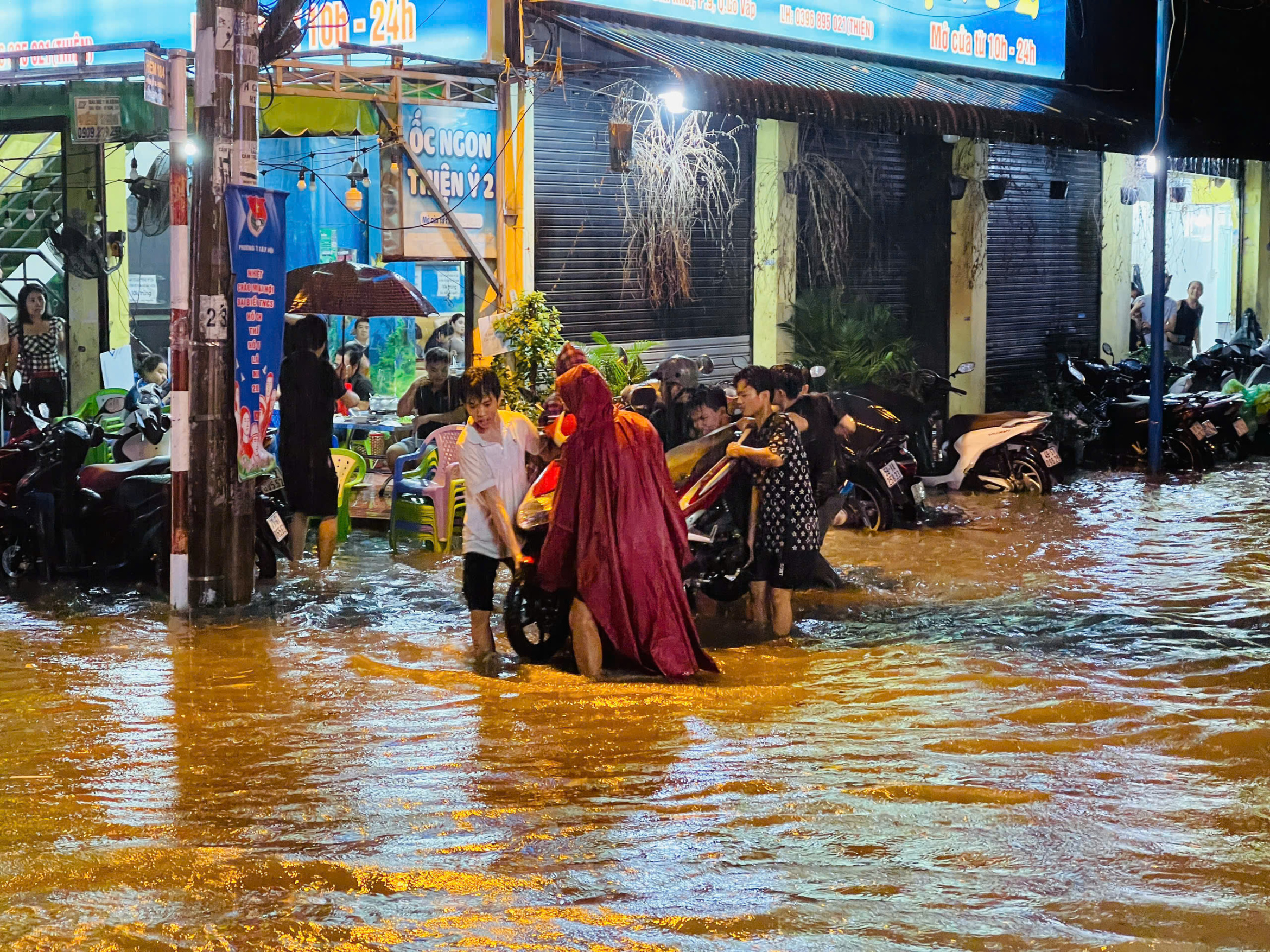 胡志明市全市大雨,旧平盛区积水严重,居民将车辆抬出积水区